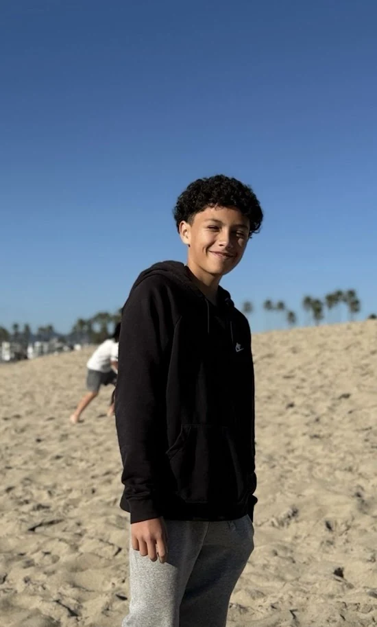 Chris standing on the beach beneath a blue sky