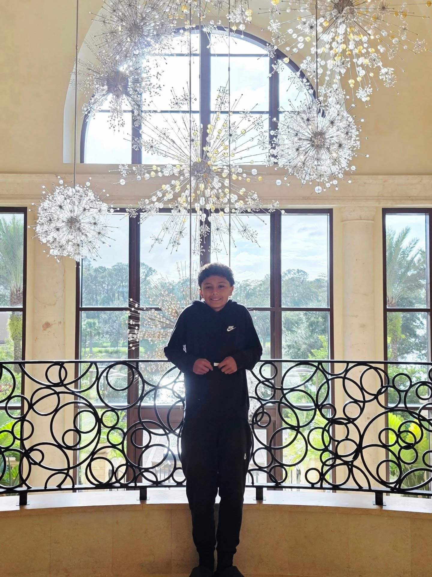 Chris standing beneath sparkling chandeliers